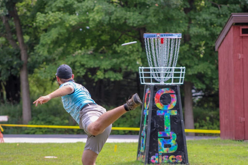 Disc golfer setting up a throw through a tree gap