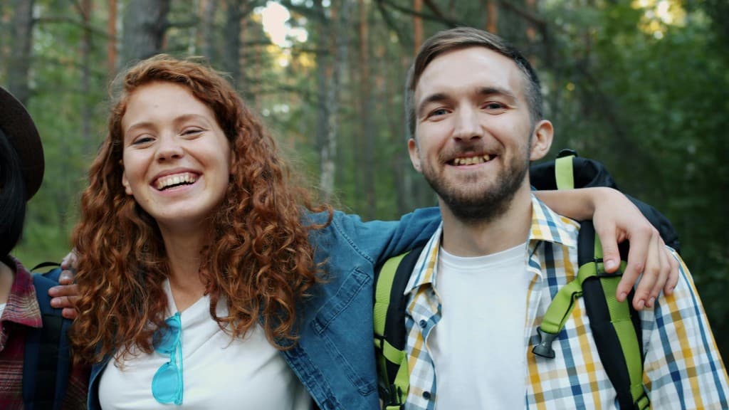 Two friends on a forest trail, phone in hand